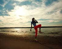 Jovem mulher que faz exercícios da aptidão na praia da areia imagens de stock Jovem mulher que faz exercícios da aptidão na praia da areia imagens de stock