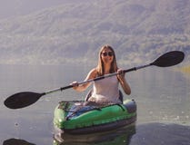 Jovem mulher que kayaking no lago foto de stock Jovem mulher que kayaking no lago foto de stock
