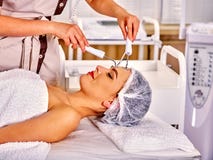 Jovem mulher que recebe a massagem facial elétrica imagem de stock royalty free Jovem mulher que recebe a massagem facial elétrica imagem de stock royalty free