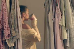 Jovem mulher Unfocused com x?cara de caf? e posi??o na frente de seu amanhecer do vestu?rio imagem de stock Jovem mulher Unfocused com x?cara de caf? e posi??o na frente de seu amanhecer do vestu?rio imagem de stock