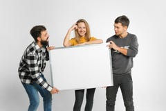 Jovens que guardam a placa branca fotografia de stock royalty free Jovens que guardam a placa branca fotografia de stock royalty free