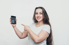 Joyful girl with long hair pokes her finger at the calculator