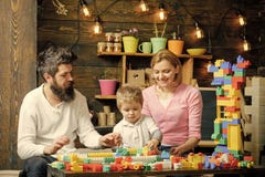 Juegos de la familia El padre, la madre y el hijo lindo juegan con los ladrillos del constructor La familia en caras ocupadas pas fotos de archivo libres de regalías Juegos de la familia El padre, la madre y el hijo lindo juegan con los ladrillos del constructor La familia en caras ocupadas pas fotos de archivo libres de regalías