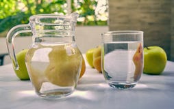 Jug and glass of water with fruits from behind royalty free stock photography Jug and glass of water with fruits from behind royalty free stock photography
