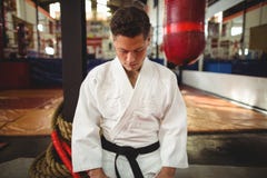 Jugador del karate que se sienta en la posición del seiza imagen de archivo Jugador del karate que se sienta en la posición del seiza imagen de archivo