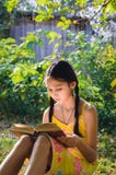 Jugendlich Mädchen, das ein Buch im Garten liest lizenzfreie stockfotos Jugendlich Mädchen, das ein Buch im Garten liest lizenzfreie stockfotos