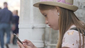 Jugendlich Mädchentourist, der Informationen suchend an einem intelligenten Telefon auf Ferien auf der Stadtstraße sitzt Technolo stock video footage Jugendlich Mädchentourist, der Informationen suchend an einem intelligenten Telefon auf Ferien auf der Stadtstraße sitzt Technolo stock video footage