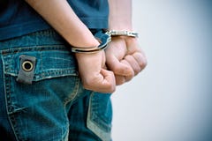 Jugendlicher in den Handschellen Jugendlicher in den Handschellen