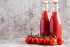Jugo de tomate en botella y tomates frescos en la tabla fotos de archivo libres de regalías Jugo de tomate en botella y tomates frescos en la tabla fotos de archivo libres de regalías