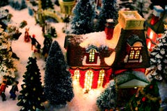 Julbydetalj med tänd byggnad och snö - selektiv fokus royaltyfri foto Julbydetalj med tänd byggnad och snö - selektiv fokus royaltyfri foto