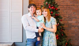 Julfamiljstående i hem- ferievardagsrum, hus som dekorerar vid Xmas-trädet arkivbild Julfamiljstående i hem- ferievardagsrum, hus som dekorerar vid Xmas-trädet arkivbild