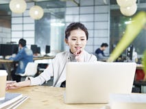 Junge asiatische Geschäftsfrau, die im Büro arbeitet lizenzfreie stockfotos Junge asiatische Geschäftsfrau, die im Büro arbeitet lizenzfreie stockfotos