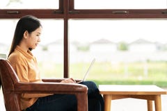 Junge attraktive asiatische Frau, die an der Cafékaffeestube denkt und schreibt Bloginformationen durch die Anwendung oder das Sc stockbild Junge attraktive asiatische Frau, die an der Cafékaffeestube denkt und schreibt Bloginformationen durch die Anwendung oder das Sc stockbild