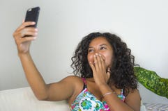 Junge attraktive und schöne glückliche schwarze afroe-amerikanisch Frau, die selfie Porträtphoto mit Handy an Feiertage apartm ma lizenzfreie stockfotos Junge attraktive und schöne glückliche schwarze afroe-amerikanisch Frau, die selfie Porträtphoto mit Handy an Feiertage apartm ma lizenzfreie stockfotos