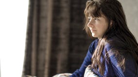 Junge brunette Frau lächelt beim in ihrem Bett morgens sitzen stockfotografie Junge brunette Frau lächelt beim in ihrem Bett morgens sitzen stockfotografie