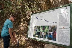 Junge, der die Informationstabelle über Quellwasserquelle, Oliena, Nuoro, Sardinien, Italien liest stockfotos Junge, der die Informationstabelle über Quellwasserquelle, Oliena, Nuoro, Sardinien, Italien liest stockfotos