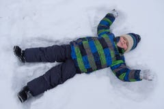Junge, der im Schnee und wellenartig bewegenden die Arme und die Beine liegt stockfotos Junge, der im Schnee und wellenartig bewegenden die Arme und die Beine liegt stockfotos