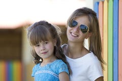 Junge dünne blonde lächelnde Mutter, Tante oder Schwester umarmt kleines hübsches Vorschultochtermädchen im netten blauen Kleid a stockfotografie Junge dünne blonde lächelnde Mutter, Tante oder Schwester umarmt kleines hübsches Vorschultochtermädchen im netten blauen Kleid a stockfotografie