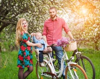 Junge Familie auf einem Garten der Fahrräder im Frühjahr Stockfotos Junge Familie auf einem Garten der Fahrräder im Frühjahr Stockfotos