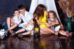 Junge Familie Cockloftausgangskindermutter-Vaterkinder sitzen des Dachbodenlachens des Dachbodens fünf Mädchen-Jungenboden glückl lizenzfreie stockbilder Junge Familie Cockloftausgangskindermutter-Vaterkinder sitzen des Dachbodenlachens des Dachbodens fünf Mädchen-Jungenboden glückl lizenzfreie stockbilder
