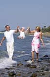 Junge Familie, die mit Tochter auf Strand in Spanien spielt Junge Familie, die mit Tochter auf Strand in Spanien spielt