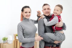 Junge Familie, Mannfrau und Kindersohn in den neuen Wohnungen Mutter hält die Schlüssel zur Wohnung Kästen mit Fracht auf a stockbilder Junge Familie, Mannfrau und Kindersohn in den neuen Wohnungen Mutter hält die Schlüssel zur Wohnung Kästen mit Fracht auf a stockbilder