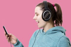 Junge Frau in den Kopfhörern mit dem Spieler in den Händen hörend Popmusik lokalisiert auf rosa Hintergrund Hören Sie moderne Mus Lizenzfreie Stockfotos Junge Frau in den Kopfhörern mit dem Spieler in den Händen hörend Popmusik lokalisiert auf rosa Hintergrund Hören Sie moderne Mus Lizenzfreie Stockfotos