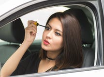 Junge Frau der Nahaufnahme, die im Auto sich setzt auf das Make-up schaut in Spiegel sitzt, wie vom äußeren Treiberfenster gesehe lizenzfreies stockfoto Junge Frau der Nahaufnahme, die im Auto sich setzt auf das Make-up schaut in Spiegel sitzt, wie vom äußeren Treiberfenster gesehe lizenzfreies stockfoto
