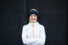 Junge Frau in der Sportkleidung, die das Kameralächeln betrachtet lizenzfreie stockfotos Junge Frau in der Sportkleidung, die das Kameralächeln betrachtet lizenzfreie stockfotos