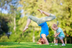 Junge Frau, die draußen, kleiner Sohn spielt neben ihr ausarbeitet Lizenzfreie Stockfotos Junge Frau, die draußen, kleiner Sohn spielt neben ihr ausarbeitet Lizenzfreie Stockfotos