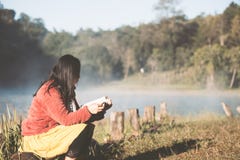 Junge Frau, die ein Buch im Naturpark mit Frische liest stockfotografie Junge Frau, die ein Buch im Naturpark mit Frische liest stockfotografie