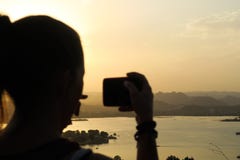 Junge Frau, die ein Foto des schönen Sonnenuntergangs in Udaipur macht stockfotos Junge Frau, die ein Foto des schönen Sonnenuntergangs in Udaipur macht stockfotos