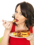 Junge Frau, die ein volles englisches Frühstück isst lizenzfreie stockfotos Junge Frau, die ein volles englisches Frühstück isst lizenzfreie stockfotos