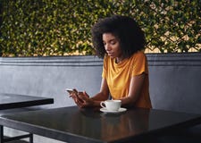 Junge Frau, die im Café unter Verwendung des Handys sitzt lizenzfreies stockfoto Junge Frau, die im Café unter Verwendung des Handys sitzt lizenzfreies stockfoto
