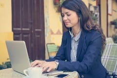 Junge Frau, die an Laptop, hörende Musik arbeitet lizenzfreie stockbilder Junge Frau, die an Laptop, hörende Musik arbeitet lizenzfreie stockbilder