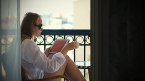 Junge Frau mit Berührungsfläche auf Hotelbalkon stock video Junge Frau mit Berührungsfläche auf Hotelbalkon stock video