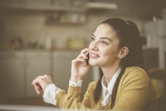 Junge Frau zu Hause, die am Handy spricht lizenzfreie stockbilder Junge Frau zu Hause, die am Handy spricht lizenzfreie stockbilder