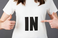 Junge Frauen-Anhänger-tragendes T-Shirt gedruckt mit IN Slogan lizenzfreie stockbilder Junge Frauen-Anhänger-tragendes T-Shirt gedruckt mit IN Slogan lizenzfreie stockbilder