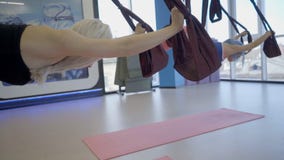 Junge Frauen üben Antischwerkraftyoga in der Hängematte im Studio stock footage Junge Frauen üben Antischwerkraftyoga in der Hängematte im Studio stock footage