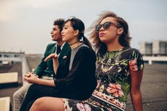 Junge Leute, die auf Dachspitze sitzen lizenzfreies stockbild Junge Leute, die auf Dachspitze sitzen lizenzfreies stockbild