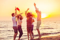 Junge Leute, die auf Strand bei Sonnenuntergang tanzen lizenzfreie stockbilder Junge Leute, die auf Strand bei Sonnenuntergang tanzen lizenzfreie stockbilder