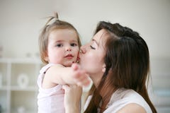 Junge Mutter, die mit ihrem Baby im Bett spielt Mutterküssen lizenzfreies stockbild Junge Mutter, die mit ihrem Baby im Bett spielt Mutterküssen lizenzfreies stockbild