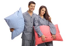 Junge Paare in den Pyjamas, die Kissen halten und das camer betrachten Stockbild Junge Paare in den Pyjamas, die Kissen halten und das camer betrachten Stockbild