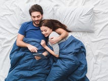 Junge Paare in des Draufsichtmorgenkonzeptes des Betts aufpassendem Film auf digitaler Tablette lizenzfreie stockfotografie Junge Paare in des Draufsichtmorgenkonzeptes des Betts aufpassendem Film auf digitaler Tablette lizenzfreie stockfotografie