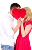 Junge Paare, die hinter dem Kissen flüstern Lizenzfreies Stockbild Junge Paare, die hinter dem Kissen flüstern Lizenzfreies Stockbild