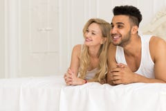 Junge Paare, die im Bett, im glückliches Lächeln-hispanischen Mann und in den Frauen-Liebhabern im Schlafzimmer liegen Stockbilder Junge Paare, die im Bett, im glückliches Lächeln-hispanischen Mann und in den Frauen-Liebhabern im Schlafzimmer liegen Stockbilder