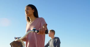 Junge Paare, die mit Fahrrad auf dem Strand 4k gehen stock video Junge Paare, die mit Fahrrad auf dem Strand 4k gehen stock video