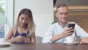 Junge Paare, die Smartphones betrachtend sich ignorieren stockfoto Junge Paare, die Smartphones betrachtend sich ignorieren stockfoto