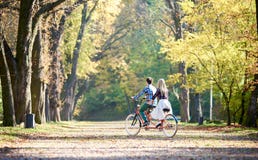 Junge Paare, gutaussehender Mann und attraktive Frau auf Tandemfahrrad im sonnigem Sommerpark oder -wald lizenzfreie stockfotos Junge Paare, gutaussehender Mann und attraktive Frau auf Tandemfahrrad im sonnigem Sommerpark oder -wald lizenzfreie stockfotos