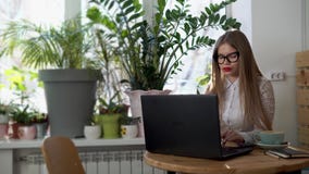 Junge schöne Geschäftsfrau, die hinter ihrem Laptop in einem hellen Raum arbeitet stock video footage Junge schöne Geschäftsfrau, die hinter ihrem Laptop in einem hellen Raum arbeitet stock video footage